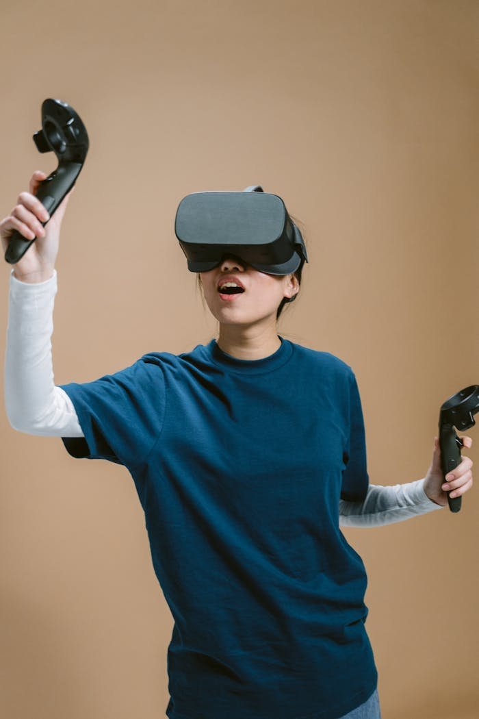 A woman wearing a VR headset and holding controllers, fully immersed in a virtual reality experience.